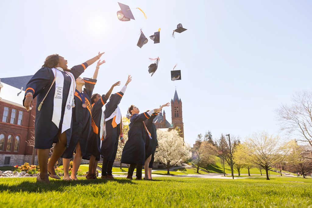 Graduating students throw their graduation caps in the air