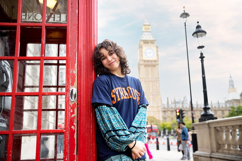 A woman stands outside a phone booth in London